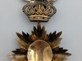 a gold brooch with a crown on top of it