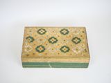 an old wooden box with a green and yellow design on it
