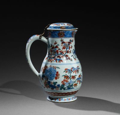 un vase bleu et blanc orné de fleurs et de feuilles