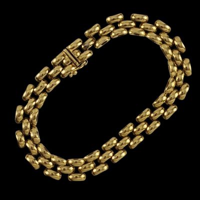 un bracelet en or avec un fermoir sur fond noir