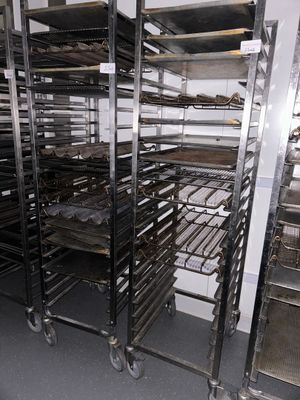 many racks with trays of food on them in the kitchen