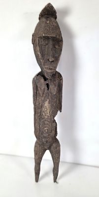 l'image d'une statue en bois représentant un homme avec un chapeau sur la tête