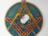 a metal medallion with a masonic symbol on it