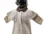 une poupée vêtue d'un manteau et d'un chapeau