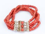 a close up of a bracelet with coral beads on a white background