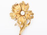 an image of a gold flower brooch with diamonds on it