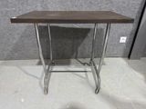 une petite table avec un plateau en bois et des pieds en métal