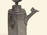 a metal watering can with a bird on it