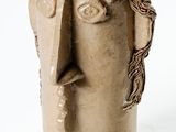 a vase that has a face on the side of it