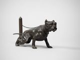 statue représentant un chien attaché à un poteau par une chaîne