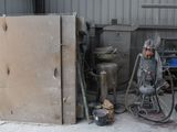 a refrigerator that is sitting in a garage next to other appliances
