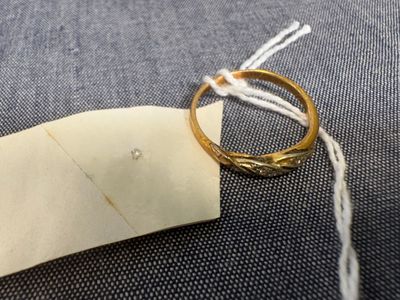une bague en or posée sur un morceau de papier, entourée d'un fil