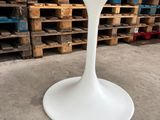 an image of a white table with a white base in a warehouse