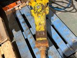 a yellow and black drill on a pallet next to some wooden pallets