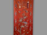 a red wall hanging with birds and flowers on it