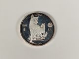une pièce d'argent sur laquelle figurent un chien et un chat