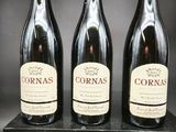trois bouteilles de vin rouge sont posées sur une boîte noire