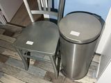 two chairs and a trash can in the corner of a room