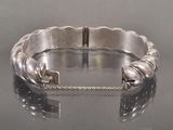 silver bracelet with a lock and chain on a reflective surface