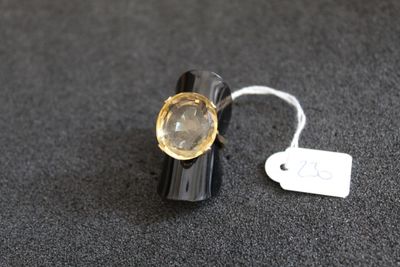 une bague noire sertie d'une pierre jaune, avec une étiquette de prix