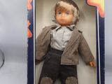 une poupée Barbie dans une boîte sur laquelle figure la photo d'un garçon en costume