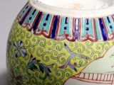 a yellow vase with blue and red designs on it
