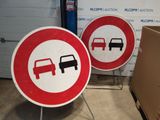 two red and white road signs on a stand