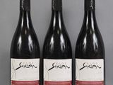 three bottles of wine are lined up on a table