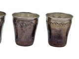 three silver cups with designs on them sitting next to each other
