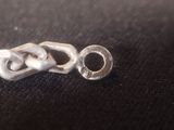a silver chain that has been placed on a black surface