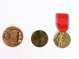 three medals on a white surface with a red, white and blue ribbon