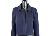 Le mannequin porte un pull bleu et un pantalon en cuir noir.