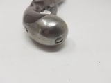 a metal object that is laying on a white surface
