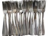 a lot of forks that are stacked together on a table
