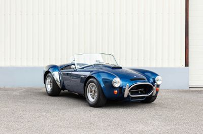 a blue sports car parked in front of a building