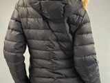 the back view of a man wearing a black jacket with a fur collar