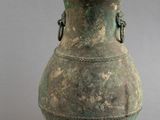 un grand vase vert surmonté de deux figurines