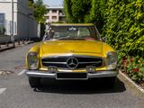 a yellow mercedes car parked on the side of the road