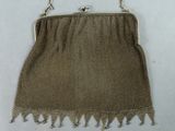 an old purse with a chain handle and fringes on it