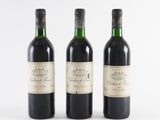 three bottles of wine sitting next to each other on a white surface