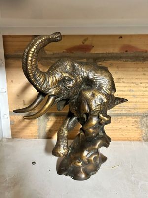 a statue of an elephant with a baby elephant on it ' s back