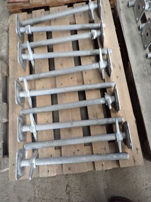 a pile of screws and bolts on a pallet next to a pair of shoes