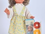 a doll that is standing next to a box of doughnuts