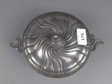an antique silver plate with a spiral design on it