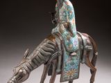 statue of a woman riding a horse with a hat on her head