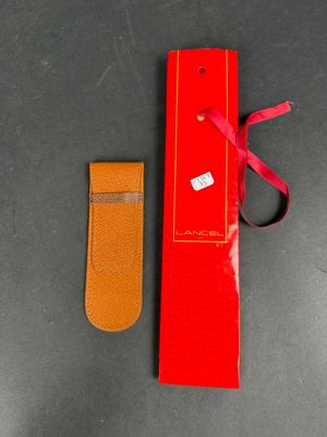 pair of red and tan leather bookmarks with a red ribbon tied to them