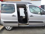 a silver van with its doors open in a parking lot