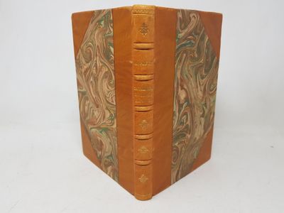 an old book with a brown leather cover and a green and white design