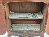 a wooden cabinet with newspaper on the shelves