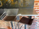 three stools and a table with a painting on the wall